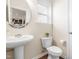 Charming powder room with pedestal sink, decorative mirror, and hardwood floors at 1104 Arden Trace Ct, Fuquay Varina, NC 27526