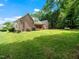 The brick house backyard features a large lawn, trees, bushes, and an outdoor deck at 11221 Paddy Hollow Ln, Raleigh, NC 27614