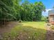The green backyard with a manicured lawn features mature trees that offer shade and privacy at 11221 Paddy Hollow Ln, Raleigh, NC 27614