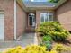 Close-up of a home's brick entrance with manicured bushes and a covered front door at 11221 Paddy Hollow Ln, Raleigh, NC 27614