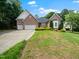 Charming brick home with a well-manicured lawn, mature trees, and a three-car garage at 11221 Paddy Hollow Ln, Raleigh, NC 27614