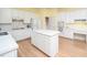 Well-lit kitchen featuring white cabinets, a center island, and updated appliances at 11221 Paddy Hollow Ln, Raleigh, NC 27614
