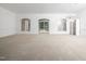 Large living room with neutral carpet, arched windows, and access to the backyard at 11221 Paddy Hollow Ln, Raleigh, NC 27614