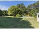 Expansive backyard showcasing the lawn, mature trees, landscaping, and in-ground pool at 1201 Kalworth Rd, Wake Forest, NC 27587