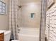 Shower and bathtub combo with stylish tile surround, mounted shower head, and a built in soap storage niche at 1201 Kalworth Rd, Wake Forest, NC 27587