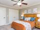 Cozy bedroom with a wood headboard, ceiling fan, decorative wall art, and a double-door closet for storage at 1201 Kalworth Rd, Wake Forest, NC 27587