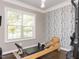 Exercise room features a window letting in natural light, wood floors, and an accent wall with birch tree pattern at 1201 Kalworth Rd, Wake Forest, NC 27587