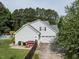 Rear exterior shot of the home, revealing an attached garage and a glimpse of the backyard pool at 1201 Kalworth Rd, Wake Forest, NC 27587