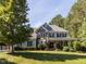 Charming two-story home with a stone and blue facade, a well-manicured lawn, and a welcoming front porch at 1201 Kalworth Rd, Wake Forest, NC 27587