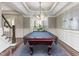 Elegant game room featuring a pool table under a modern chandelier with stairs adjacent at 1201 Kalworth Rd, Wake Forest, NC 27587