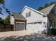 Attached two-car garage and driveway, with stone detailing and manicured landscaping at 1201 Kalworth Rd, Wake Forest, NC 27587