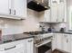 Close-up of a modern kitchen featuring stainless steel appliances, custom cabinetry, and granite countertops at 1201 Kalworth Rd, Wake Forest, NC 27587