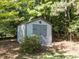 Storage shed nestled among trees and landscaping in the backyard at 1201 Kalworth Rd, Wake Forest, NC 27587
