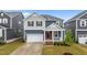 Charming two-story home featuring a red front door, a well-manicured lawn, and an attached garage at 125 Shadowdale Ln, Rolesville, NC 27571