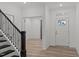 Inviting foyer with a staircase featuring dark wooden bannisters and light wood-look flooring at 125 Shadowdale Ln, Rolesville, NC 27571