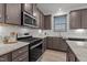 Well-equipped kitchen with a stainless steel range, granite countertops, and dark wood cabinetry at 125 Shadowdale Ln, Rolesville, NC 27571
