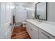 Well-lit bathroom with a modern vanity, wood-look floors, and a shower-tub combo at 129 E Chestnut Ave, Wake Forest, NC 27587