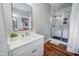 Bathroom featuring a single vanity with white cabinets, a modern mirror, and glass shower at 129 E Chestnut Ave, Wake Forest, NC 27587