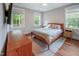Bright bedroom featuring a bed, natural light, and hardwood floors at 129 E Chestnut Ave, Wake Forest, NC 27587