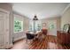 Dining room with natural light, wood floors, modern lighting, and dining table with seating for six at 129 E Chestnut Ave, Wake Forest, NC 27587