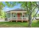 Charming home with a welcoming front porch, red door, and beautifully landscaped front yard at 129 E Chestnut Ave, Wake Forest, NC 27587