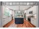 Bright kitchen features white cabinets, stainless appliances, and a center island with granite countertops at 129 E Chestnut Ave, Wake Forest, NC 27587