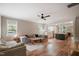 Open-concept living room with hardwood floors, a large sectional sofa, and a view of the kitchen at 129 E Chestnut Ave, Wake Forest, NC 27587
