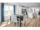 Sunlit dining area with a dark wood table, white chairs, and blue patterned curtains at 1424 Rollman Farm Rd, Raleigh, NC 27603