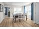 Bright dining area features a modern table, comfortable seating, and large windows with blue curtains at 1424 Rollman Farm Rd, Raleigh, NC 27603