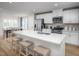 Modern kitchen features white cabinets, stainless steel appliances, and a large island with bar stool seating at 1424 Rollman Farm Rd, Raleigh, NC 27603