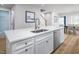Kitchen island with white cabinetry, a stainless steel sink, and stainless dishwasher, opening to dining area at 1424 Rollman Farm Rd, Raleigh, NC 27603