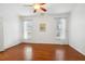 Bright bedroom featuring hardwood floors, ceiling fan, and large windows at 149 Hutson Ln, Clayton, NC 27527