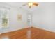 Bright bedroom features hardwood floors, ceiling fan, and natural light from the two windows at 149 Hutson Ln, Clayton, NC 27527