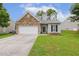 Charming home with stone accents, dormer windows, attached two-car garage, and well-maintained lawn at 149 Hutson Ln, Clayton, NC 27527