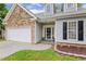 Charming home with stone accents, dormer windows, attached two-car garage, and well-maintained lawn at 149 Hutson Ln, Clayton, NC 27527