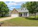 Charming front exterior with stone accents, dormer windows, a well-manicured lawn, and an attached garage at 149 Hutson Ln, Clayton, NC 27527