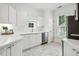 Bright kitchen featuring white cabinets, quartz countertops, stainless steel appliances, and tiled flooring at 149 Hutson Ln, Clayton, NC 27527