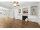 Cozy living room with a fireplace, built-in shelving and cabinetry, and wood flooring at 149 Hutson Ln, Clayton, NC 27527