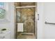 Bathroom shower with glass door, tile surround, shower head, and towel rack at 149 Hutson Ln, Clayton, NC 27527