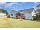 Backyard featuring lush lawn, tall trees, and partially-covered outdoor seating at 174 Tafton Dr, Wendell, NC 27591