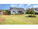 Grassy backyard featuring mature trees, landscaping, and privacy fencing at 174 Tafton Dr, Wendell, NC 27591