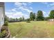 Expansive backyard with lush green grass, mature trees, and a wooden fence for privacy at 174 Tafton Dr, Wendell, NC 27591