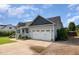 Side view of a gray single-Gathering home with a two-car garage and green lawn at 174 Tafton Dr, Wendell, NC 27591