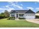 Charming single-story home with a well-manicured lawn, flower beds, and attached two-car garage at 174 Tafton Dr, Wendell, NC 27591