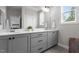 Modern bathroom featuring double sinks, gray cabinetry, and white countertops; perfect for a refreshing and stylish space at 190 Wendover Pkwy, Pittsboro, NC 27312
