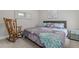 Comfortable bedroom featuring rocking chair, queen bed with floral comforter, and wall art at 190 Wendover Pkwy, Pittsboro, NC 27312