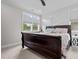 Bright bedroom featuring a wooden bed frame, neutral-toned bedding, and a window with natural light at 190 Wendover Pkwy, Pittsboro, NC 27312