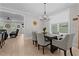Elegant dining area with wood floors, a modern chandelier, and a view into the cozy living area at 190 Wendover Pkwy, Pittsboro, NC 27312