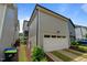 Side view of a two-car garage with white doors and well-maintained landscaping at 190 Wendover Pkwy, Pittsboro, NC 27312