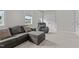 Cozy living room features a gray sofa, recliner, neutral walls, and natural light from the windows at 190 Wendover Pkwy, Pittsboro, NC 27312